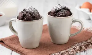 Due mug cake al cioccolato, spolverati di zucchero a velo, pronti per essere gustati.