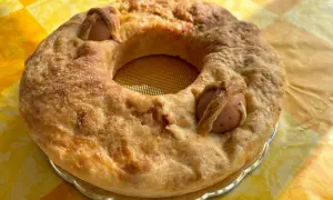 Casatiello napoletano dorato, con uova intere incastonate nell'impasto, pronto per essere gustato.