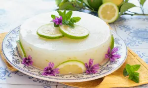 Delizioso gelo di limone decorato con fette di limone, fiori viola e foglie di menta.