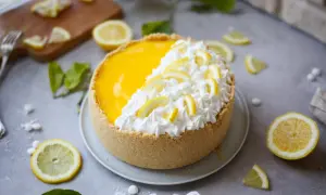 Delizioso cheesecake al limone con crema e fette di limone, pronto per essere gustato.