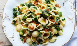 Orecchiette cime di rapa fumanti, un piatto tradizionale pugliese con pasta fresca, verdure amare e mollica tostata.