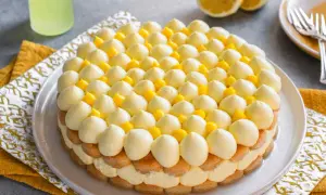 Delizioso tiramisù al limoncello, con strati di savoiardi, crema al limone e decorazioni di panna e cubetti di limone.