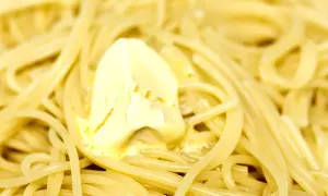 Un piatto di pasta in bianco fumante, con una generosa noce di burro che si scioglie lentamente tra gli spaghetti.