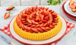 Deliziosa crostata di fragole, con una base dorata e un ripieno cremoso, ricoperta da fragole fresche affettate.