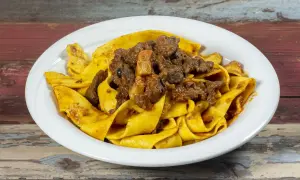 Pappardelle al cinghiale, un piatto ricco e saporito, con pasta fresca e ragù di cinghiale cotto lentamente.