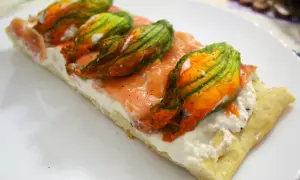 Focaccia con fiori di zucca, salmone affumicato e ricotta. Un piatto colorato e gustoso.