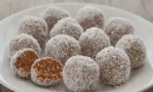 Dolci palline di cocco, una delizia da gustare in ogni momento. Una è stata aperta, rivelando il suo interno morbido e invitante.