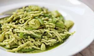 Un piatto di trofie al pesto, un classico della cucina ligure, con un condimento verde brillante e saporito.