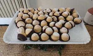 Dolcetti "tette delle monache" spolverati di zucchero a velo, un'antica ricetta che narra storie di conventi e sapori autentici.