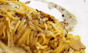 Tagliolini al tartufo, un piatto cremoso e profumato, con scaglie di tartufo nero che ne esaltano il sapore.
