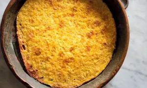 Farinata di ceci appena sfornata, dorata e croccante, in una teglia di rame. Una deliziosa ricetta da provare subito!