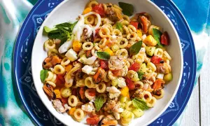 Deliziosa insalata di pasta con cozze, calamari, gamberi, pomodorini e basilico fresco. Un piatto estivo perfetto.