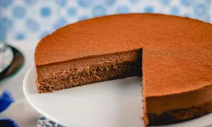 Una deliziosa torta Lisbona al cioccolato, con una soffice mousse e una base croccante, spolverata di cacao.