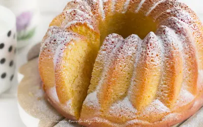 Un soffice ciambellone allo yogurt, cosparso di zucchero a velo, pronto per essere gustato.