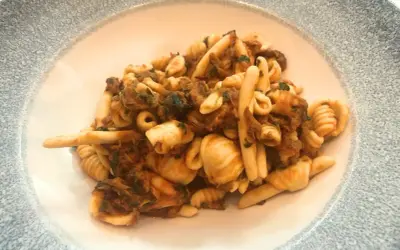Un piatto invitante di trofie alla carlofortina, con pasta fresca e un ricco sugo di pesce.