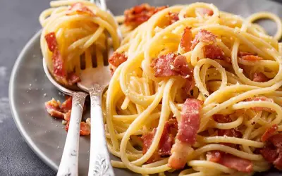 Spaghetti alla carbonara ricetta: un piatto cremoso con guanciale croccante e pecorino romano.