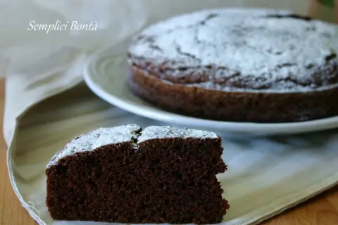 Una fetta di torta con kefir e cacao, spolverata di zucchero a velo, su un tovagliolo.