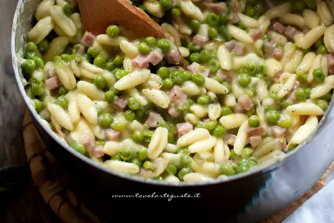 Pasta con prosciutto cotto e piselli, un piatto cremoso e saporito, pronto per essere gustato.