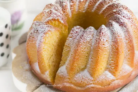 Un soffice ciambellone allo yogurt, cosparso di zucchero a velo, pronto per essere gustato.