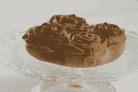 Pitta nchiusa, un dolce invitante a forma di rosa, servito su un piatto di vetro.