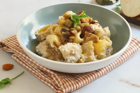 Un piatto invitante di pasta con melanzane in bianco, condita con una crema saporita e guarnita con menta fresca.