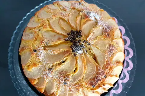 Torta ricotta e pere, ricetta originale napoletana, con fette di pera disposte a raggiera e spolverata di zucchero a velo.