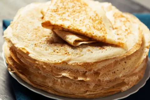 Una pila di crepes all'acqua dorate e sottili, pronte per essere farcite.