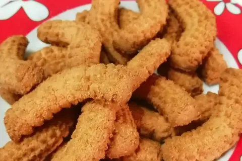 Un piatto pieno di krumiri fatti in casa, pronti per essere gustati. La ricetta perfetta per un dolce semplice e delizioso.