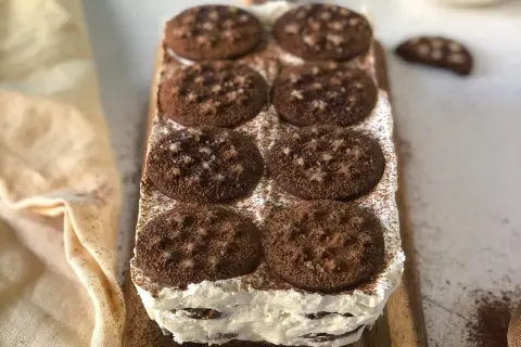 Deliziosa torta pan di stelle, stratificata con crema e biscotti al cacao, spolverata di cacao amaro.