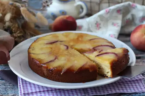 Deliziosa torta di pesche rovesciata, con fette di pesca caramellate sulla superficie dorata e soffice impasto.