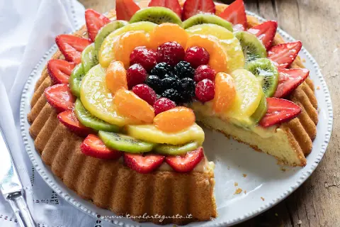 Una deliziosa crostata morbida alla frutta, con fragole, kiwi, mandarini e frutti di bosco su una base soffice e crema pasticcera.
