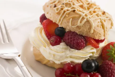 Delizioso pasticcino con chantilly e frutti di bosco freschi, pronto per essere gustato.