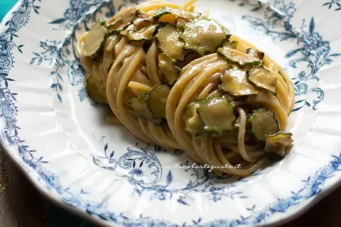 Spaghetti alla Nerano, un piatto cremoso con zucchine fresche su un piatto decorato.