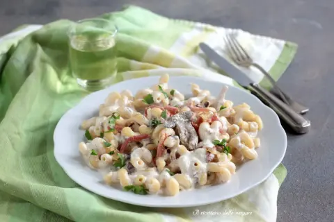 Piatto di pasta alla boscaiola cremosa con funghi e pancetta, guarnita con prezzemolo fresco.