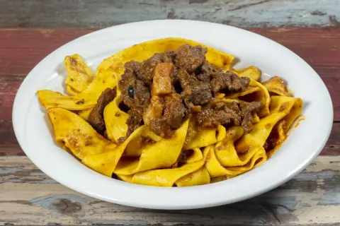 Pappardelle al cinghiale, un piatto ricco e saporito, con pasta fresca e ragù di cinghiale cotto lentamente.