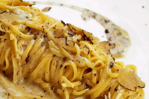 Tagliolini al tartufo, un piatto cremoso e profumato, con scaglie di tartufo nero che ne esaltano il sapore.