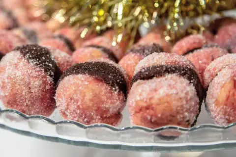 Dolci con alchermes, rotondi e zuccherini, con una fascia scura al centro, pronti per le feste.