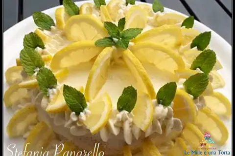 Delizia al limone, una torta fresca e profumata, decorata con fette di limone e foglie di menta.