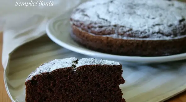 Una fetta di torta con kefir e cacao, spolverata di zucchero a velo, su un tovagliolo.