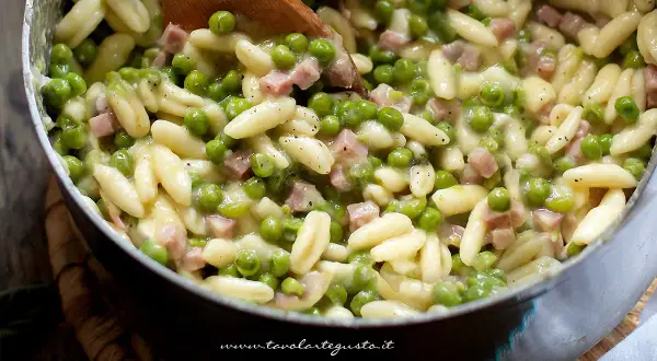 Pasta con prosciutto cotto e piselli, un piatto cremoso e saporito, pronto per essere gustato.