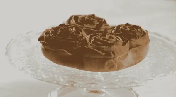 Pitta nchiusa, un dolce invitante a forma di rosa, servito su un piatto di vetro.