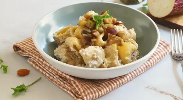 Un piatto invitante di pasta con melanzane in bianco, condita con una crema saporita e guarnita con menta fresca.