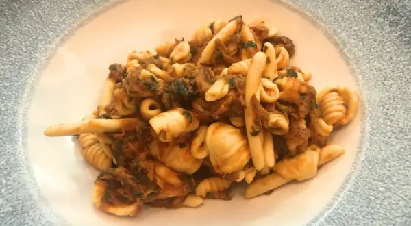 Un piatto invitante di trofie alla carlofortina, con pasta fresca e un ricco sugo di pesce.