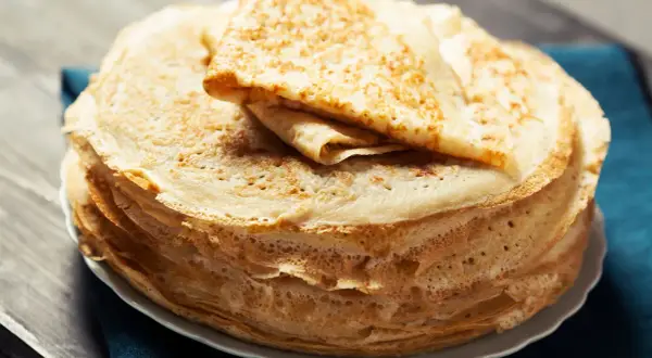 Una pila di crepes all'acqua dorate e sottili, pronte per essere farcite.