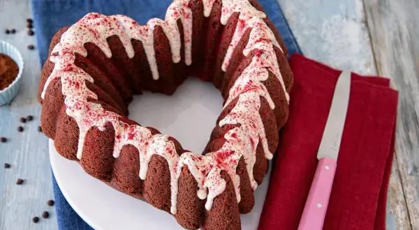 Cuore di torta barbabietola e cioccolato, glassato con glassa bianca e spolverata di polvere rossa.