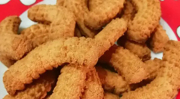 Un piatto pieno di krumiri fatti in casa, pronti per essere gustati. La ricetta perfetta per un dolce semplice e delizioso.