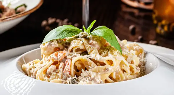 Pasta fredda cremosa con ricotta, pomodorini e basilico fresco, un piatto estivo perfetto.