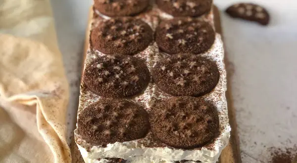 Deliziosa torta pan di stelle, stratificata con crema e biscotti al cacao, spolverata di cacao amaro.