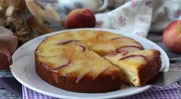 Deliziosa torta di pesche rovesciata, con fette di pesca caramellate sulla superficie dorata e soffice impasto.