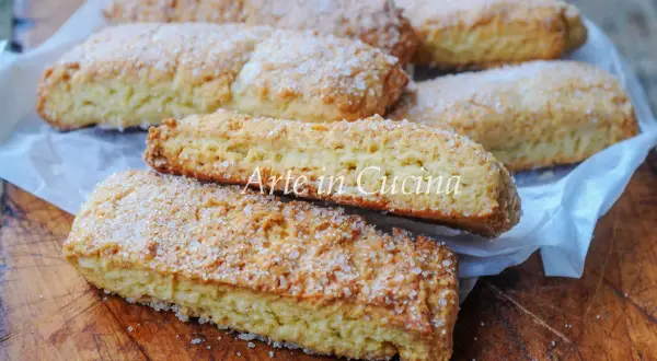 Biscotti pasta frolla dorati e croccanti, cosparsi di zucchero, pronti per essere gustati.
